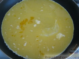Омлет с крабовыми палочками и сыром: Разогреть сковороду, налить растительное масло. Вылить на разогретую сковороду подготовленные яйца и уменьшить огонь, накрыть крышкой.
