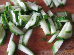 Сырный салат с колбасой: Огурцы свежие помыть и нарезать соломкой.