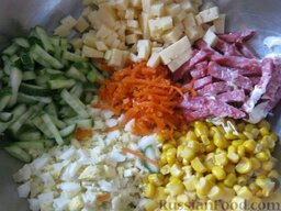 Сырный салат с колбасой: Морковь очистить, помыть и натереть на терке для корейской моркови. Можно еще порезать мелко. Все ингредиенты выложить в миску.