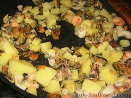 Теплый салат из картофеля с морепродуктами: Добавить картофель и обжарить все вместе 3 минуты.