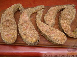 Сом в ореховой панировке: Подготовленные кусочки рыбы выложить на тарелку или разделочную доску на 5 минут, чтобы панировка закрепилась.