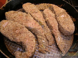 Сом в ореховой панировке: На сковороде разогреть 2 ст. ложки растительного масла. Выложить рыбу на сковороду. Жарить на средне-слабом огне 5-7 минут.