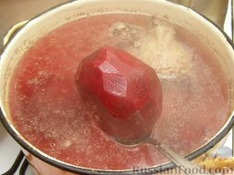 Красный борщ "Три хозяйки": Свеклу очистить и целиком опустить в кипящий бульон. Варить до готовности свеклы (35-40 минут).
