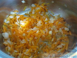 Экономный рыбный суп: Разогреть сковороду. Налить растительное масло. Выложить тертую морковь и вторую часть лука. Обжарить, помешивая, на среднем огне 3-4 минуты.