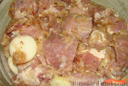 Шашлык из свинины: Высыпать измельченный лук в мясо. Добавить к мясу специи, соль и лимонный сок, перемешать.