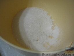 Пирог песочный с абрикосами: Включить духовку. В миску насыпать сахар, ванильный сахар и разрыхлитель для теста. Перемешать.
