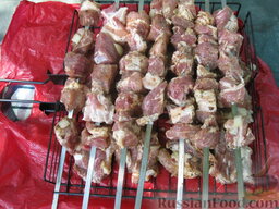 Шашлык из свинины с чесноком: Нанизать мясо на шампуры. Лук и чеснок с мяса не стряхиваем, пусть жарятся вместе.