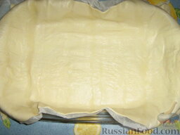 Пирог с ветчиной, сыром и творогом: Слоеное тесто, раскатанное достаточно тонко, помещаем в форму для выпечки, вместе с бумагой.