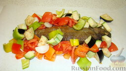 Форель с овощами: Жареную форель выложить на пергамент, выложить овощи по бокам рыбы, сбрызнуть оливковым маслом.