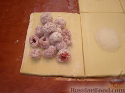 Пирожки-слойки с малиной: На каждый кусочек теста выложить примерно по 10 ягод малины.