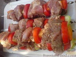 Шашлык свиной с овощами: Помыть помидоры и сладкий перец. Помидоры нарезать кружочками. Перец порезать кусочками.   Подготовленное мясо надеть на шампуры, вставляя между мясом кусочки перца и помидоров.