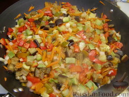 Овощная икра жареная: Выложить лук, чеснок и морковь к остальным овощам, перемешать. Накрыть крышкой и продолжать тушить овощную икру еще 15-20 минут. В конце приготовления, когда почти вся жидкость выпарится, убавить огонь до слабого и обжаривать икру, помешивая, 5-10 минут.