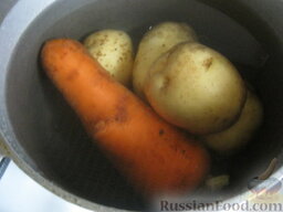 Салат "Оливье" с курицей: Помыть картофель и морковь. Вскипятить чайник. Залить овощи кипятком. Отварить на среднем огне овощи в мундире до готовности, около 20 минут. Воду слить. Овощи остудить и очистить.