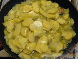 Тортилья (картофельная запеканка по-испански): Усилить огонь и выложить в масло картошку (чеснок не вынимать). Перемешать. Готовить картофель в масле 5 минут.