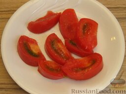 Салат с креветками и помидорами: Выкладываем дольки в плоский салатник. Слегка солим.