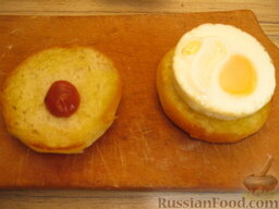 Мини-бургеры с запеченным яйцом: Взять нижние половинки булочек. На каждую выложить по 0,5-1 ч. ложке кетчупа. Сверху выложить запеченное яйцо.