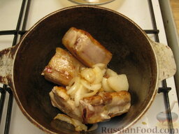 Айнтопф со свиными ребрами: Переложить ребра вместе с жиром в казанок, добавить лук, перемешать и жарить еще 5 минут.