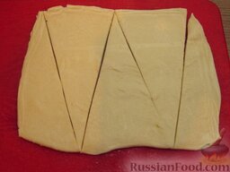 Мини-рогалики из слоеного теста (в микроволновке): Слоеное тесто разморозить.  Раскатать тесто до толщины 2-3 мм и нарезать его треугольниками. Ширина основания треугольника 5 см, а высота треугольника 10 см