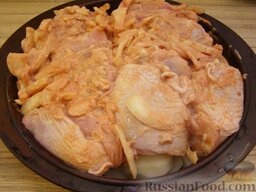 Запеченная курица с имбирем и чесноком: На картошку выложить курицу с имбирем, чесноком, луком (вместе с маринадом), равномерно распределить бедрышки кожей вверх.  Поставить форму в духовку (можно накрыть фольгой, но не обязательно) на 40 минут.