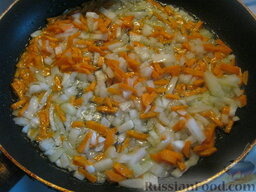 Постная овощная солянка: Разогреть сковороду. Налить растительное масло. Выложить лук и морковь. Тушить, помешивая, на среднем огне 2-3 минуты.