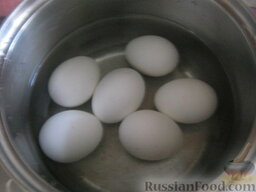 Оливье "Шапка деда Мороза": Яйца залить холодной водой, сварить вкрутую (10 минут после закипания). Охладить и очистить.