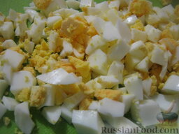 Оливье "Шапка деда Мороза": С половины яиц снять белки. Остальные яйца и желтки нарезать кубиками.