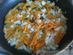Щи из квашеной капусты с перловкой: Разогреть сковороду, налить растительное масло. В горячее масло выложить лук и морковь. Тушить, помешивая, на среднем огне 2-3 минуты.