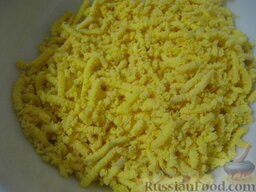 Салат "Мимоза" с рисом: Натереть желтки на мелкой терке.