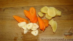 Запеченные ребрышки: Как приготовить свиные ребрышки, запеченные в духовке:    Почистить имбирь, морковь и чеснок. Нарезать кусочками имбирь и морковь, нарезать пластинками чеснок.