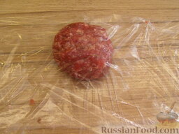 Котлета для гамбургера: Отделить кусочек фарша весом 70-80 г, сформировать шарик. Положить мясной шарик между двумя слоями пленки.