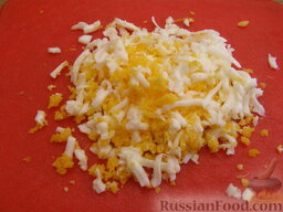 Крабовый салат с овощами: Яйца отварить вкрутую (10 минут), очистить и натереть на крупной терке.