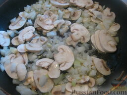 Солянка с капустой, грибами и консервированной рыбой: Разогреть сковороду. Налить растительное масло. Выложить в сковороду лук и грибы. Тушить на среднем огне, помешивая, 4-5 минут.