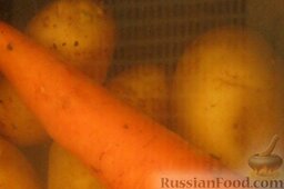Салат "Оливье" с языком: Картофель и морковь помыть. Выложить в кастрюлю, залить холодной водой. Дать закипеть. Варить на среднем огне в мундире до готовности, около 20-25 минут.
