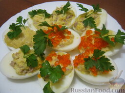 Яйца, фаршированные печенью трески: Украсить фаршированные яйца зеленью и красной икрой. Подавать охлажденными.  Приятного аппетита!