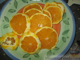 Утка в апельсиновом соусе: Один апельсин нарезаем тонкими ломтиками. Из второго апельсина и лимона выжимаем сок, который добавляем в кастрюлю с уткой.