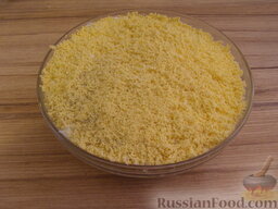 Салат "Мимоза" с рисом и копченой рыбой: Сверху раскрошить на салат яичные желтки (натереть на мелкой терке или протереть через сито).