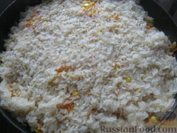 Вегетарианский плов с овощами: Сверху засыпать пропаренный рис, распределяя его равномерно по всей площади сковороды.