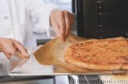 Классическая сырная пицца: 11. Готовую сырную пиццу аккуратно перенести с камня на противень, а с него переложить на доску, убирая пергамент. Камень поместить в духовку на 5 минут, а затем выложить на него вторую пиццу.     Готовую сырную пиццу порезать порционными кусочками и подавать сразу же.