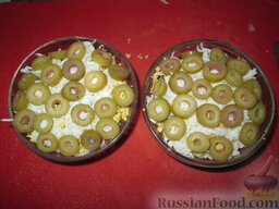Салат слоеный  "Куранты": Оливки или маслины нарезать колечками, выложить аккуратно.