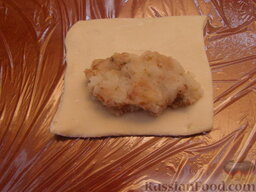 Пирожки из слоеного теста с картошкой и фасолью: Духовку разогреть до температуры 200 градусов.    Слепить пирожки из слоеного теста. На одну половину каждого квадрата теста выложить 1-1,5 ст. ложки фарша.