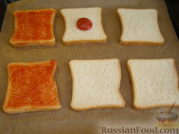 Гренки с кетчупом и сыром: Противень застелить пергаментной бумагой.    Каждый кусочек тостового хлеба густо намазать кетчупом.