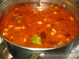 Солянка с копченостями: Когда картофель будет готов, влить томатную заправку и перемешать. Добавить лавровый лист. Варить солянку с копченостями на самом маленьком огне 5-7 минут.