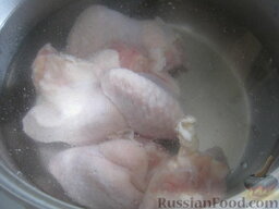Рассольник из курицы с перловкой: Как варить рассольник с перловкой из курицы:    Курицу (куриные крылышки) помыть и выложить в кастрюлю. Залить 2 л холодной воды, поставить на огонь. Довести до кипения, снять пену, варить курицу около 20 минут.