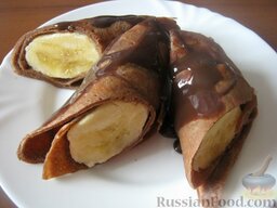 Шоколадные блинчики с бананом: Завернуть банан в блинчик.  Подавать шоколадные блинчики с бананами, полив растопленным шоколадом.  Приятного аппетита!