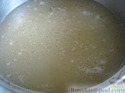 Гороховый суп со свиными ребрышками: Мясо вынуть. Бульон процедить через сито. С гороха слить воду. В бульон выложить горох. Дать закипеть, снять пенку. Выложить картофель. Посолить. Варить на среднем огне около 20 минут.