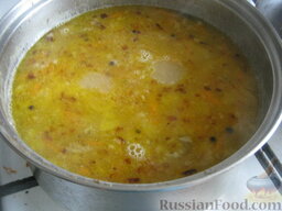 Гороховый суп со свиными ребрышками: Мясо почистить от костей, выложить в суп. Добавить зажарку, перец горошком и  лавровый лист. Варить гороховый суп со свиными ребрышками 5 минут под крышкой.