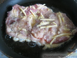 Свиные стейки на кости, под сыром: Разогреть сковороду, налить растительное масло. В горячее масло выложить подготовленный стейк. Жарить свиной стейк на кости на небольшом огне 4-5 минут, до румяной корочки.