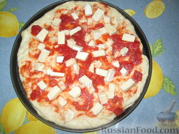 Пицца с сыром бри, моцареллой и вялеными помидорами: Тесто разделить на 4 части. Смазать формы для выпечки пиццы растительным маслом. В каждую положить часть теста и руками потихоньку распределить тесто по всей форме.   Распределить по поверхности пиццы помидоры. Посыпать сыром моцарелла, нарезанным кубиком, и сыром бри, тоже нарезанным. (Напоминаю, что корочку с бри срезать не нужно! Она съедобная и придает сыру некоторую пикантность.)