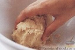 Песочное печенье с вишенкой: 2. Ввести в масляную смесь муку и руками замесить однородное тесто. Сформировать рулет и нарезать его на 16-20 кружочков, сформировать из них шарики.