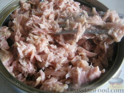Слоеный салат с тунцом: Открыть баночку консервированного тунца, слить лишнее масло, тунца размять вилкой.